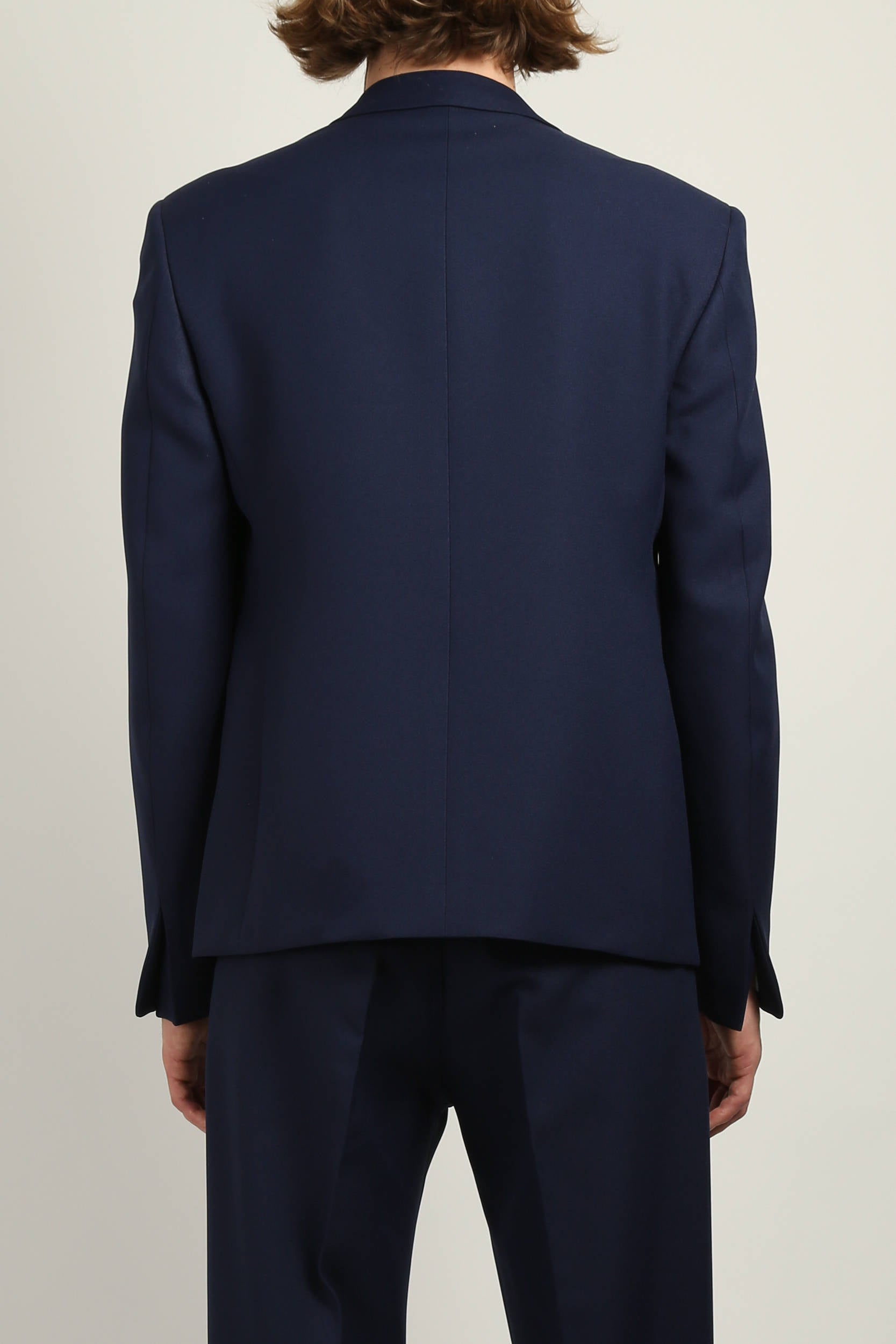 Back view of Navy gaberdine buttonless blazer by Random Identities highlighting clean tailored silhouette