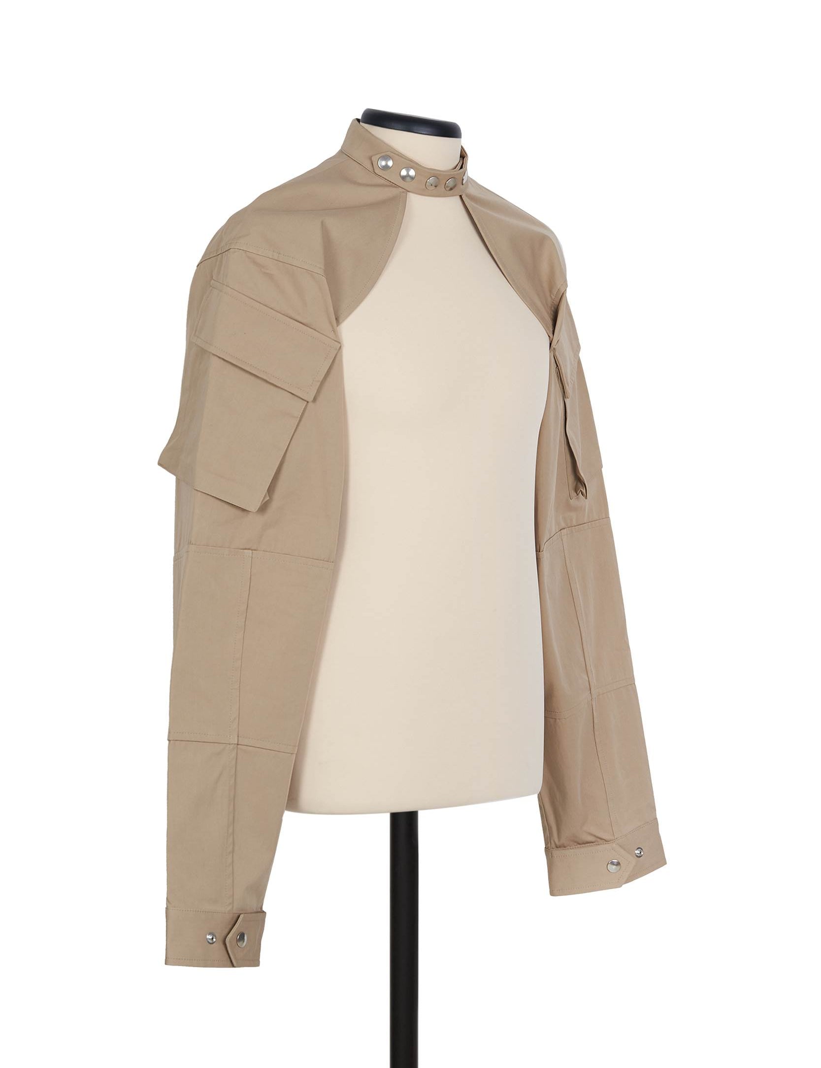 Beige cotton shrug jacket by Random Identities. front view with press buttons