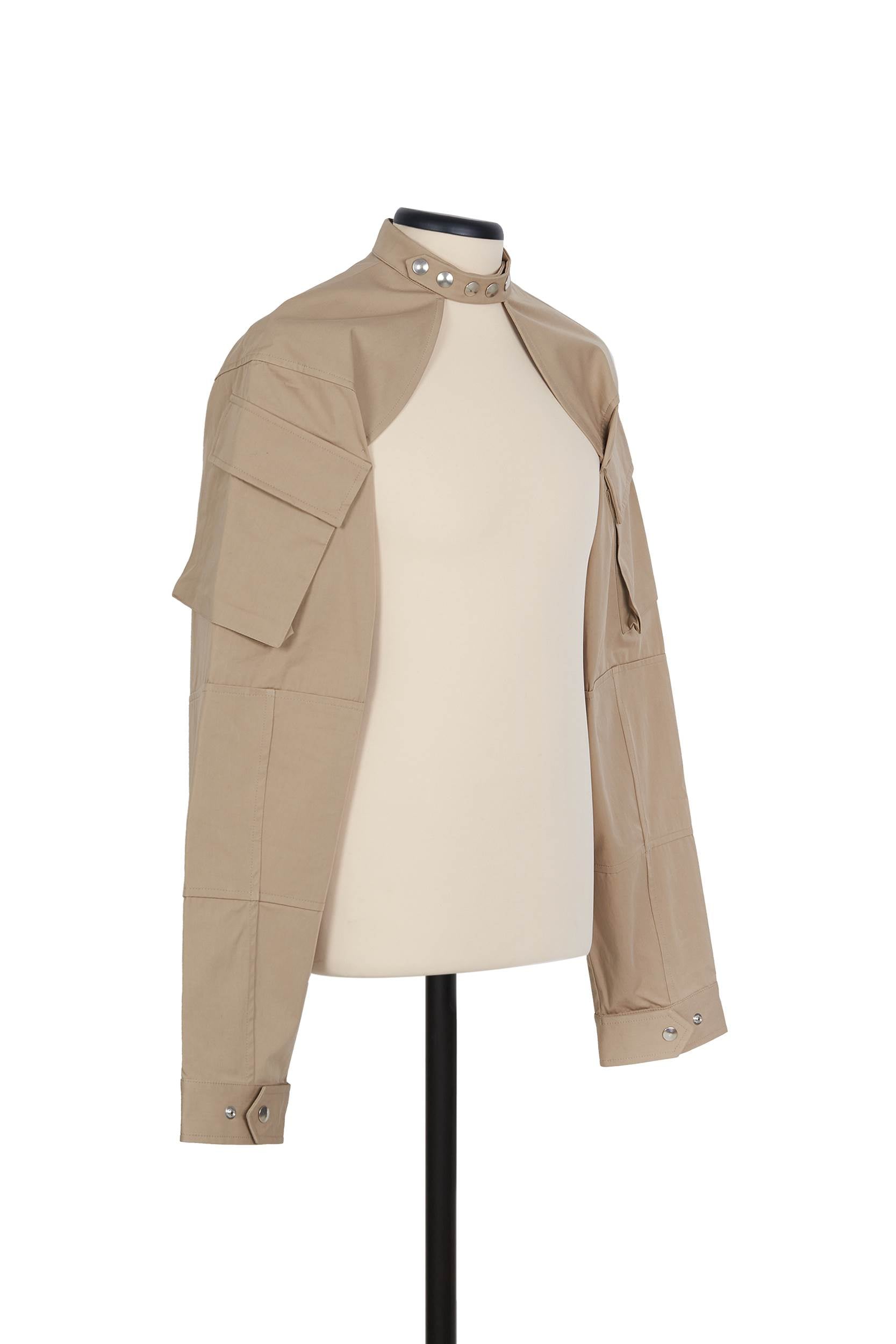 Beige cotton shrug jacket by Random Identities. front view with press buttons