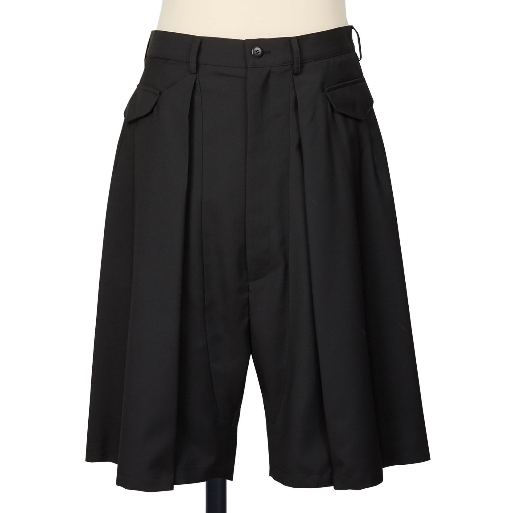 Random Identities black tailored shorts with deep reverse pleats, horizontal flap pockets, and skirty silhouette