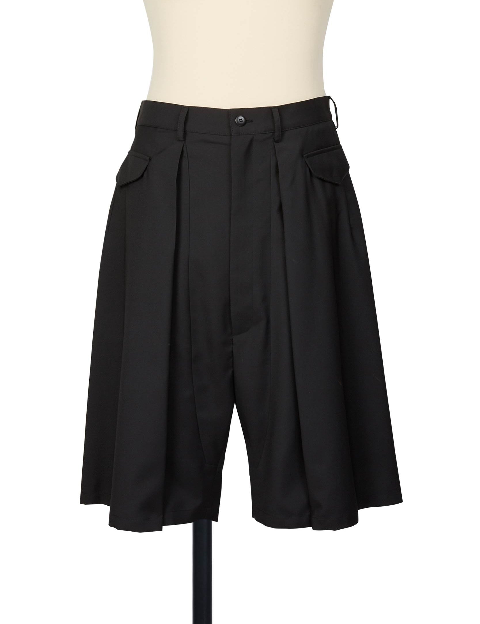 Random Identities black tailored shorts with deep reverse pleats, horizontal flap pockets, and skirty silhouette