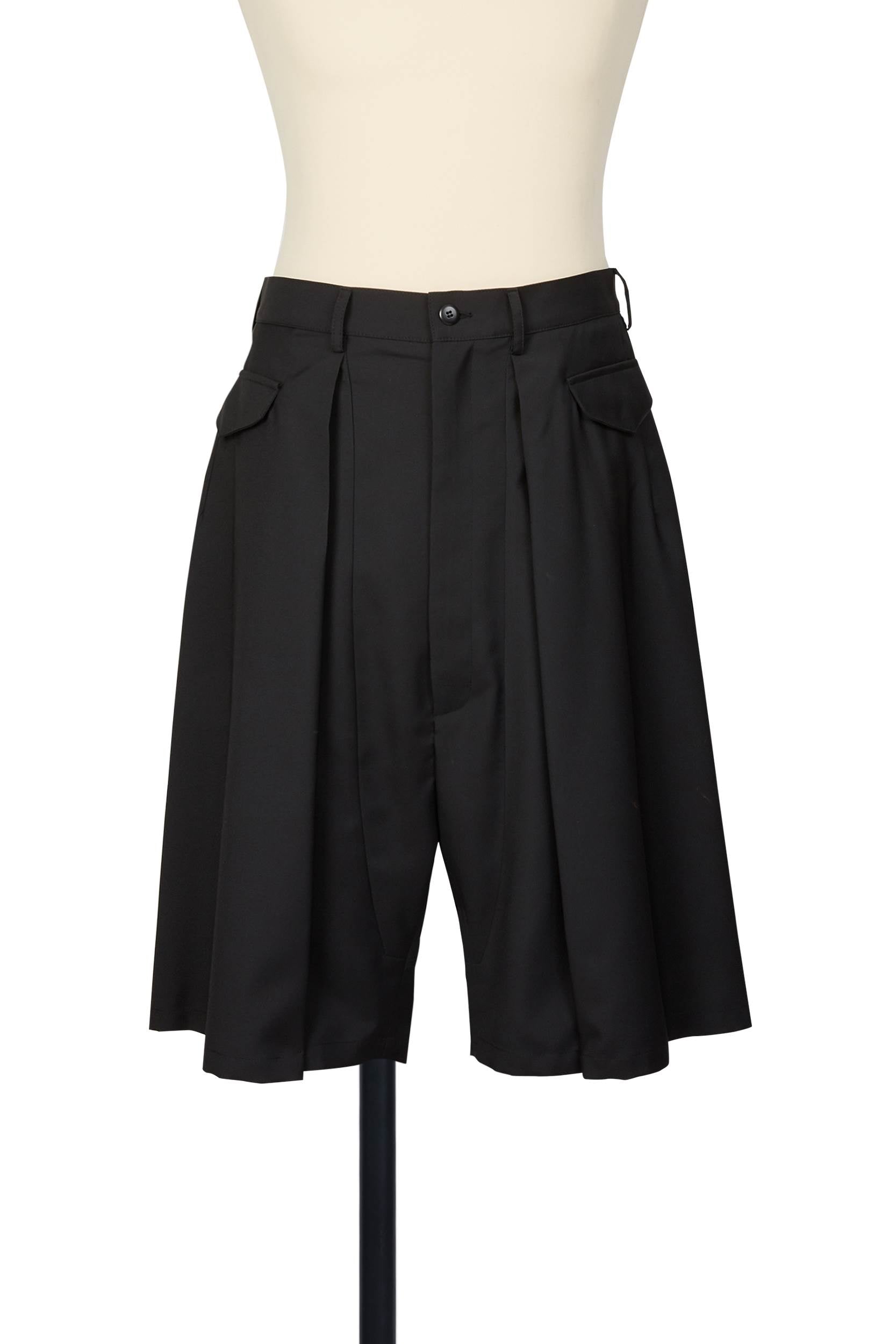 Random Identities black tailored shorts with deep reverse pleats, horizontal flap pockets, and skirty silhouette