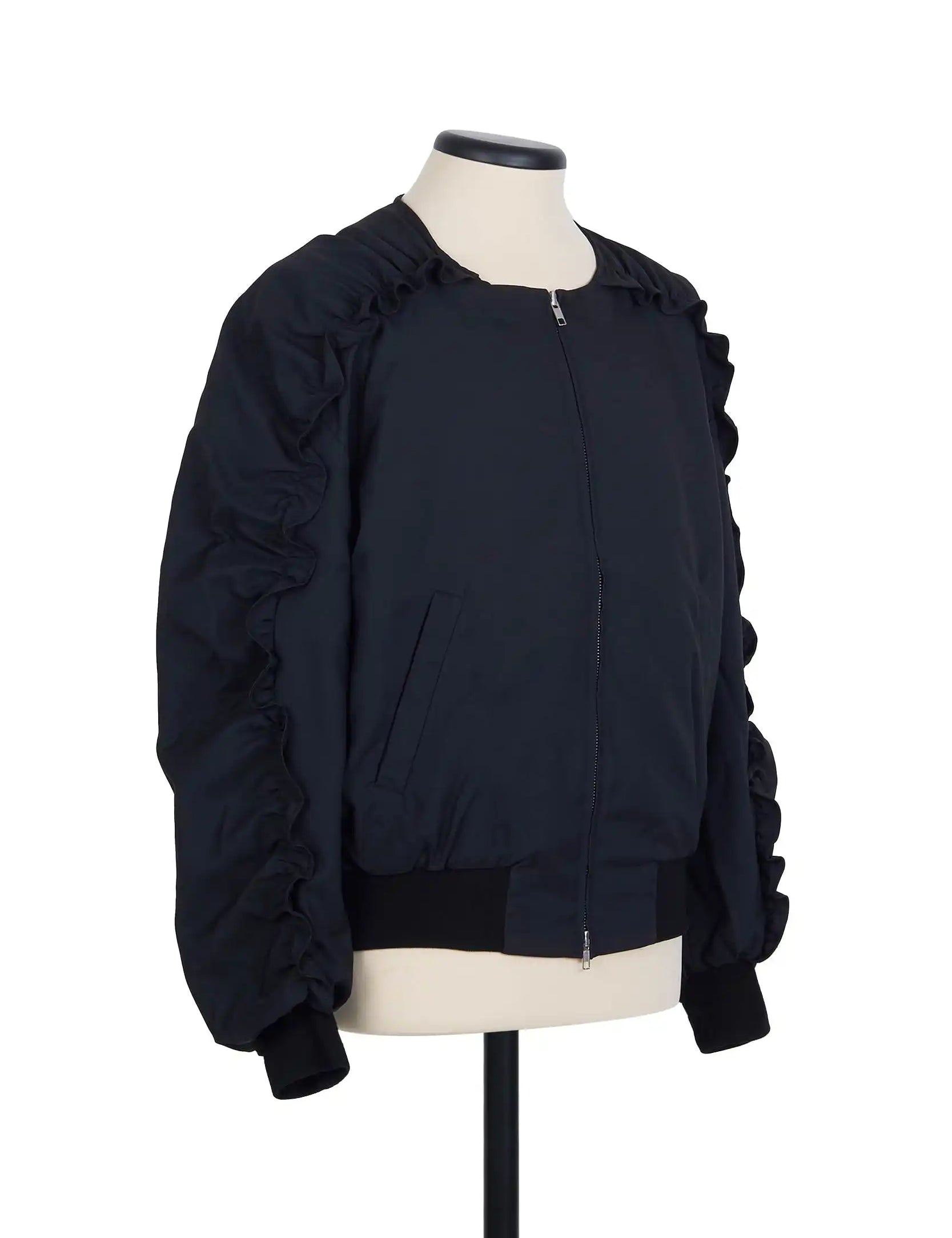 Black collarless half raglan bomber featuring exaggerated ruffled sleeve stitching