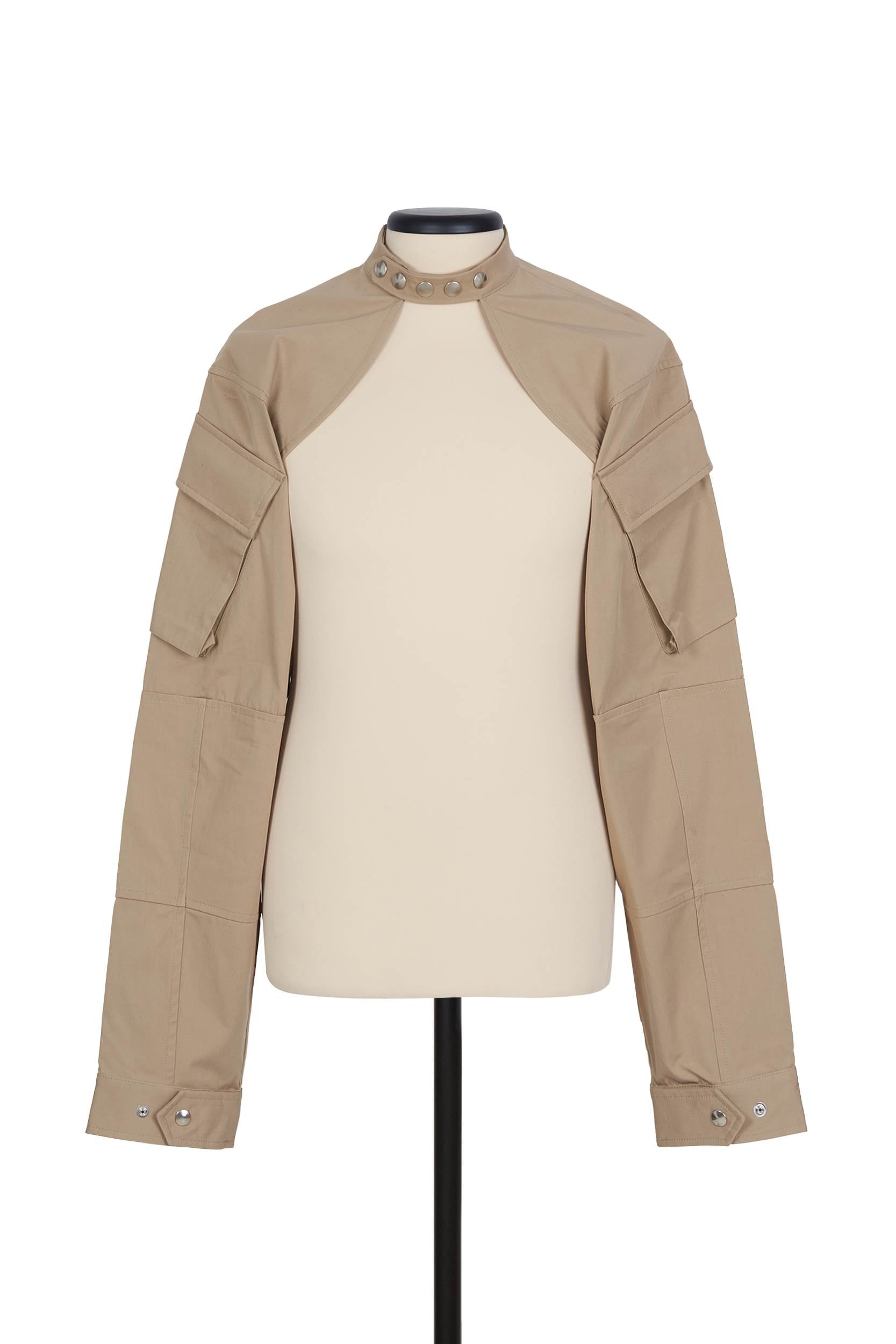 Random Identities Shrug Jacket in Beige. collarless with press-button fastening and sleeve cargo pocket