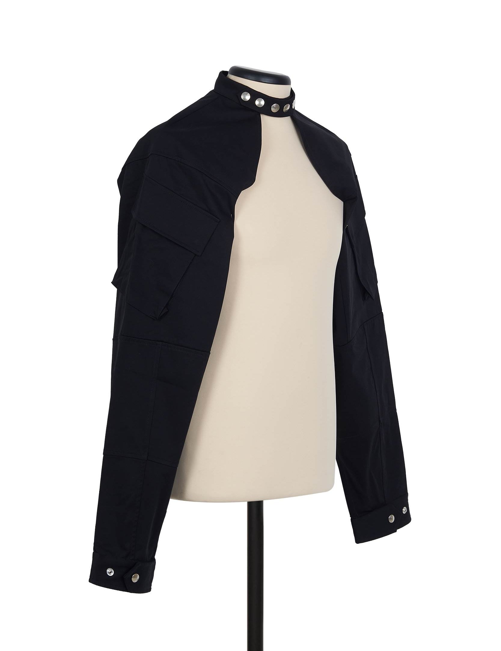 Black cotton shrug jacket by Random Identities. front view with press buttons