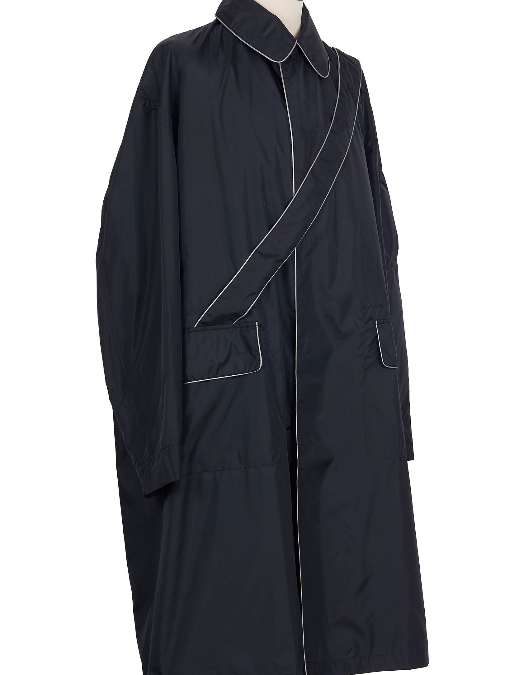 Black nylon raincoat with contrast piping, flap pockets, sleeve zip pocket and single vent by Random Identities