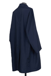 Random Identities Navy raincoat featuring diagonal strap detail and flap pockets