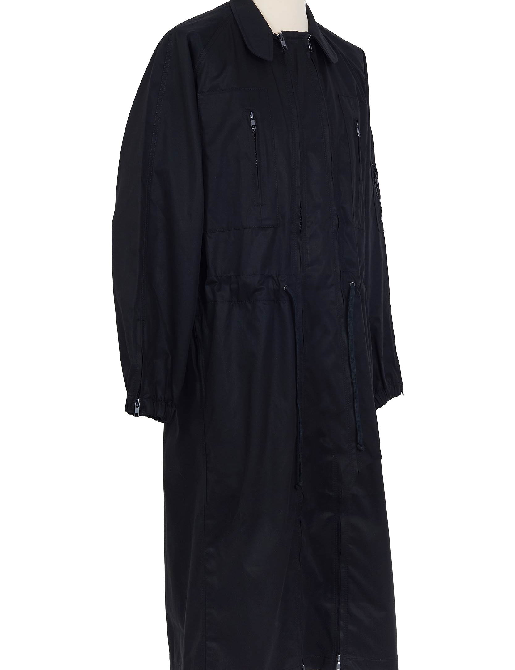 Black cotton gabardine coat. spread collar, zip chest and waist pockets, upper‑sleeve zip pocket