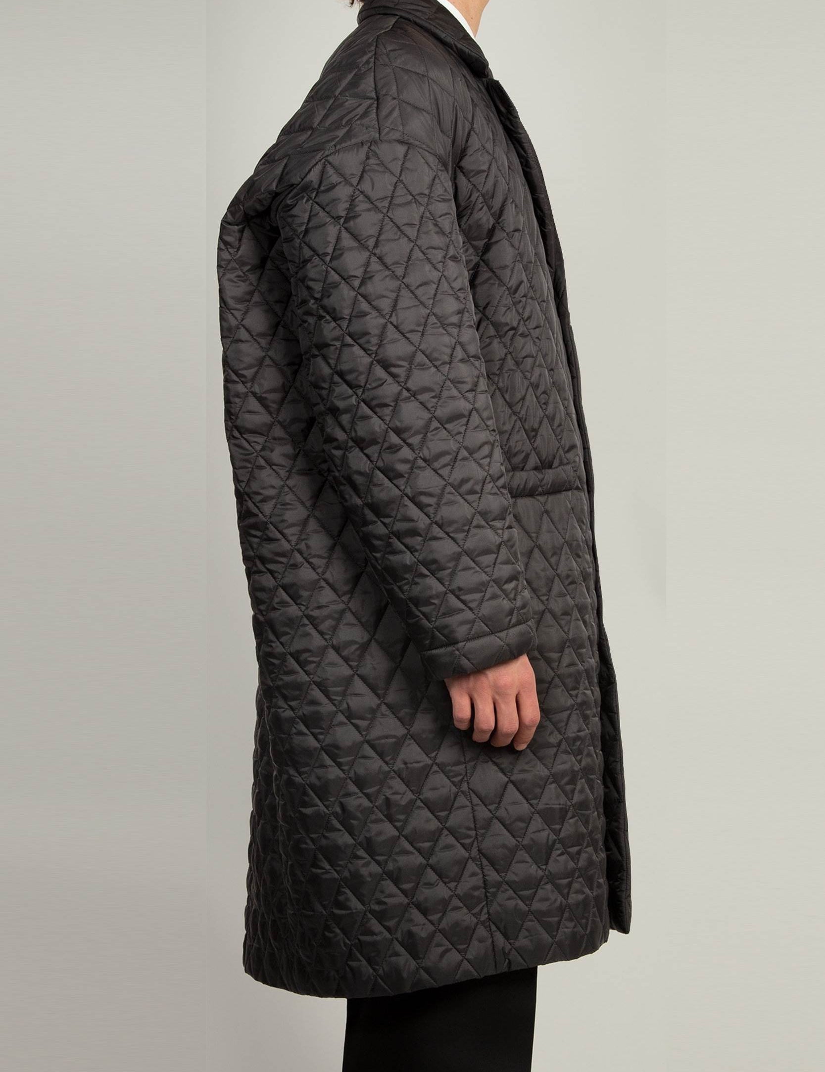 Black single breasted coat with front welt pockets and rounded back profile