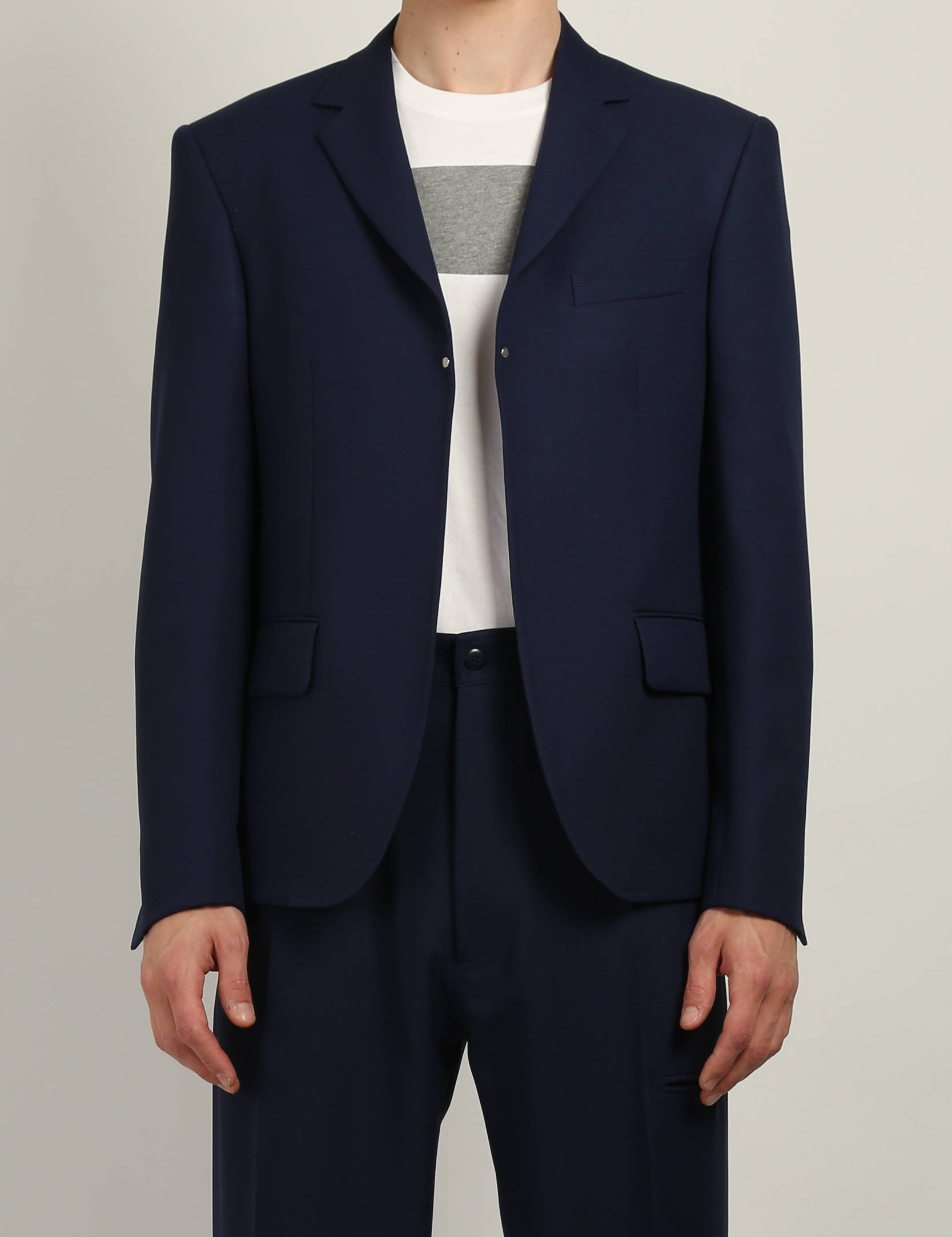 Random Identities Buttonless Blazer in Navy, gaberdine blazer with notch lapel, flap pockets, and metal rivet detailing, front view