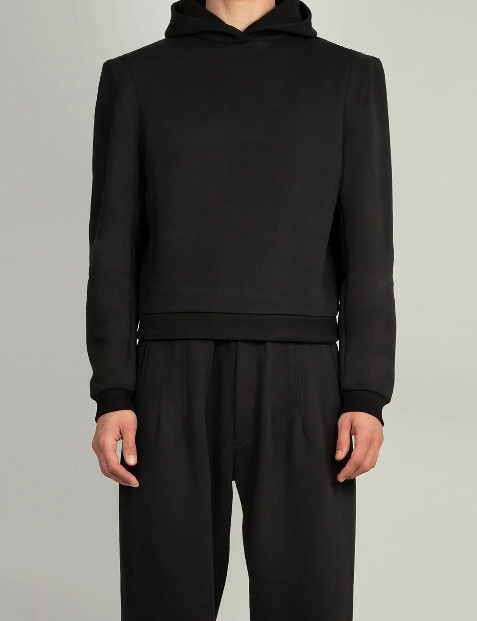 Random Identities Constructed Shoulder Hoody in Black with two-piece sleeve and darted sleevehead, front view