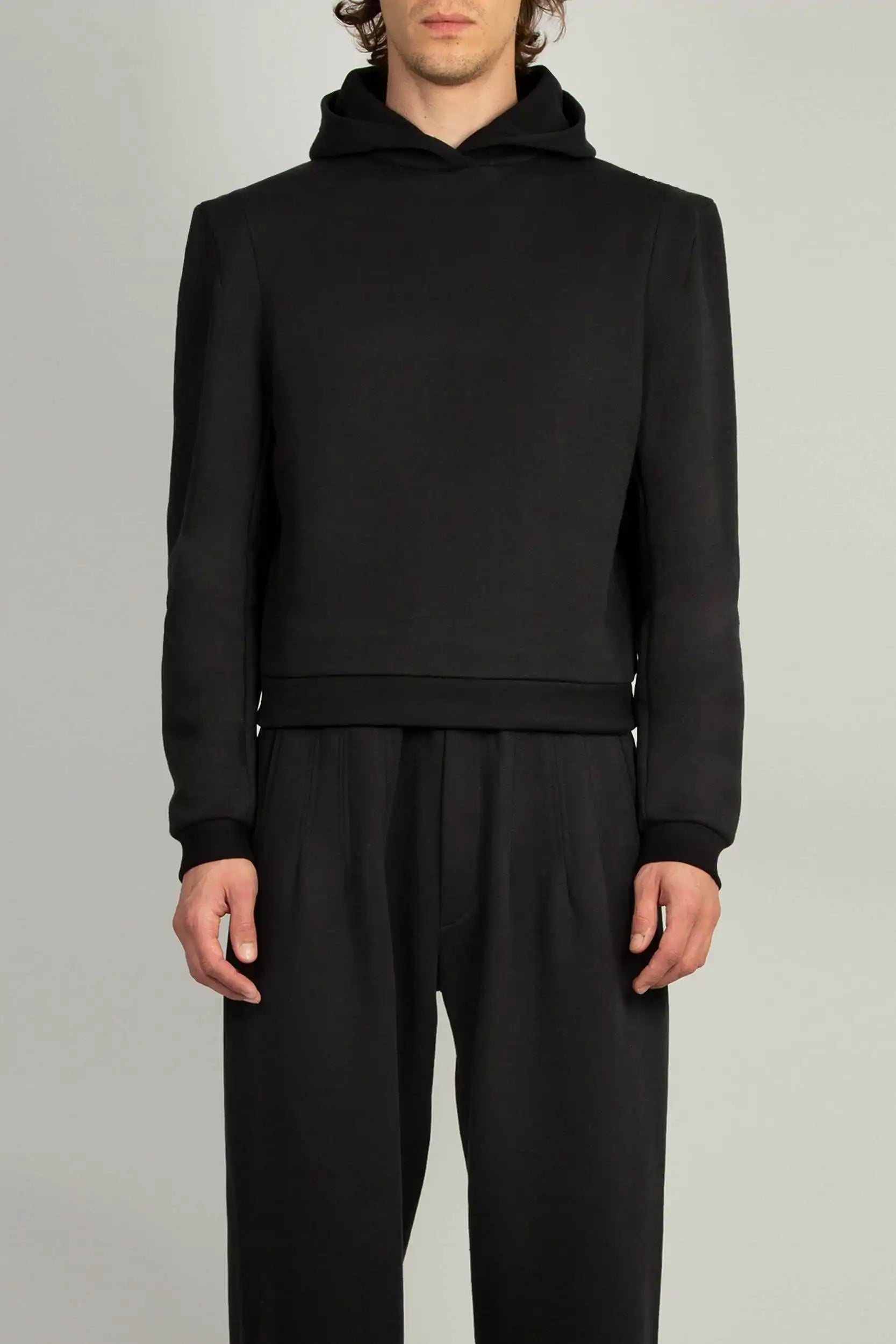 Random Identities Constructed Shoulder Hoody in Black with two-piece sleeve and darted sleevehead, front view